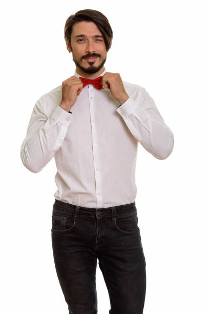 istock Studio shot of handsome man standing while holding bow tie and winking 668723126