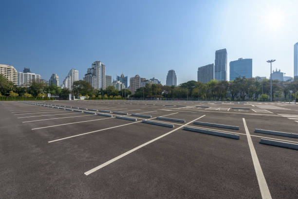 istock Empty parking lot at city center with blue sky and sun reflection 668724118