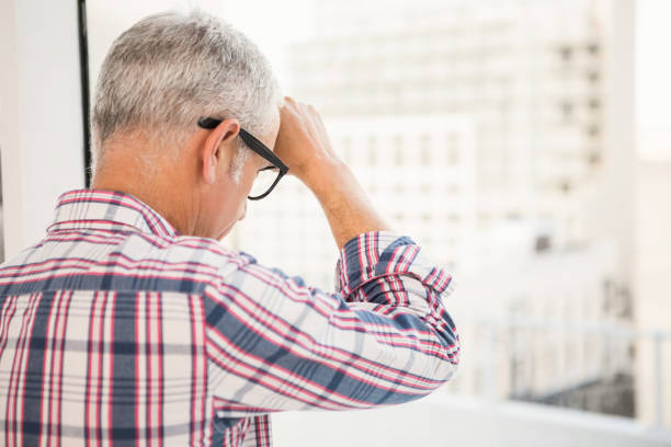 istock Troubled casual businessman leaning against window 668729550