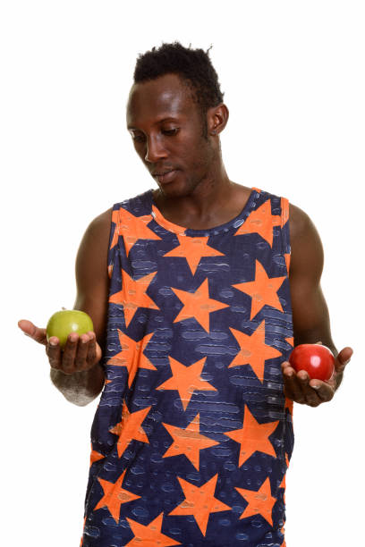 istock Young black African man choosing between green apple and red apple 668741864