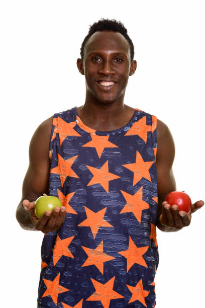 istock Young happy black African man smiling while holding green apple and red apple 668743746