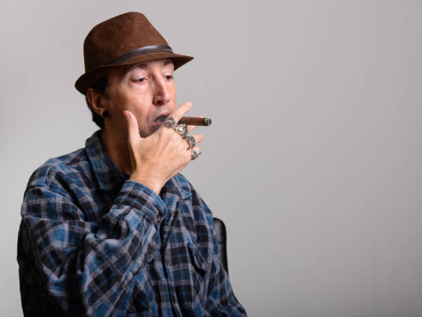 istock Studio shot of mature gangster man thinking while smoking cigar 668764026