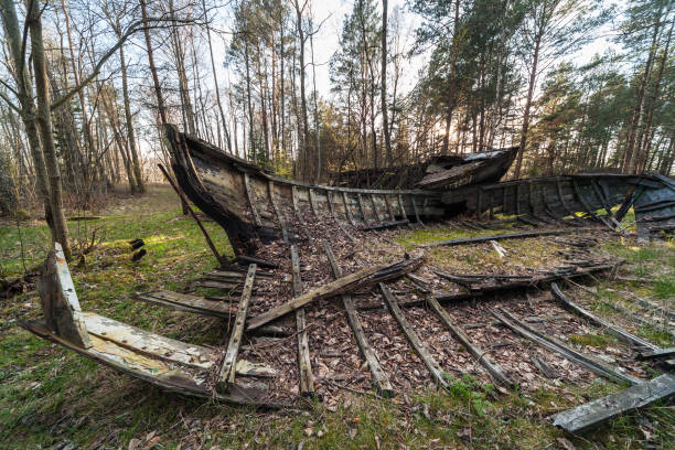 A graveyard for old fishing boats in Mazirbe, by Baltic sea. One wooden boat can be seen in the background