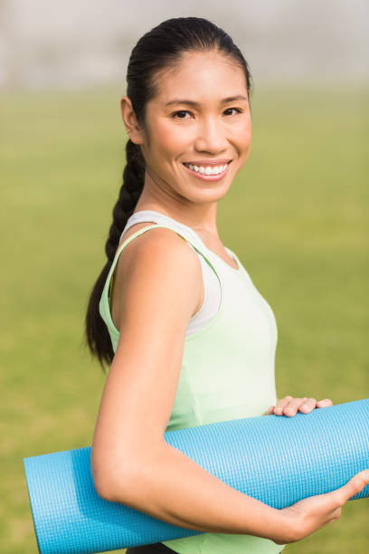 istock Smiling sporty woman holding exercise mat 668782772