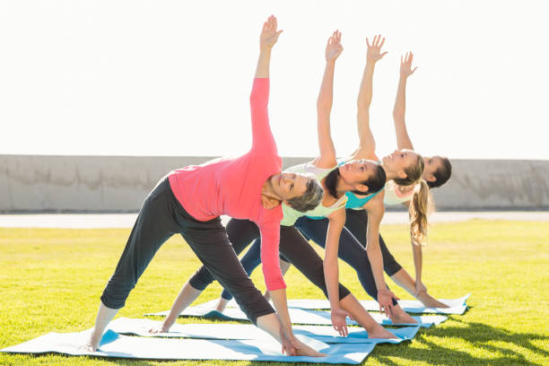 istock Sporty women doing triangle pose in yoga class 668807634