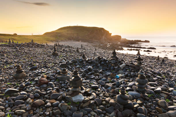 Rock Towers at Sunrise on a Pebbly Beach stock photo