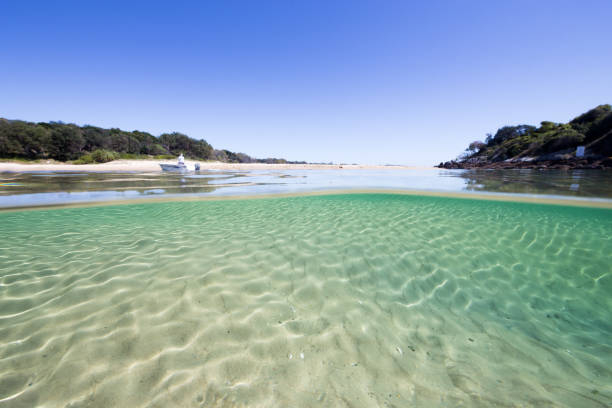 An Under-Over Water View of a Crystal Clear Beach Scene stock photo