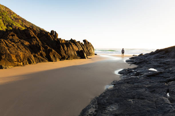 istock Single Figure in the Morning Light on a Deserted Beach 668831660