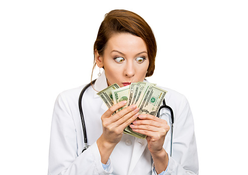 Closeup portrait greedy, miserly health care professional, female doctor holding, looking at her money dollars in hand, fascinated isolated white background. Negative human emotion, facial expressions