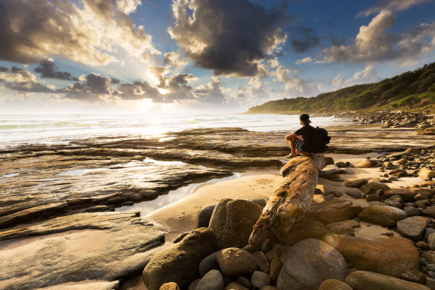 Hiker Watches Explosive Coastal Sunrise stock photo