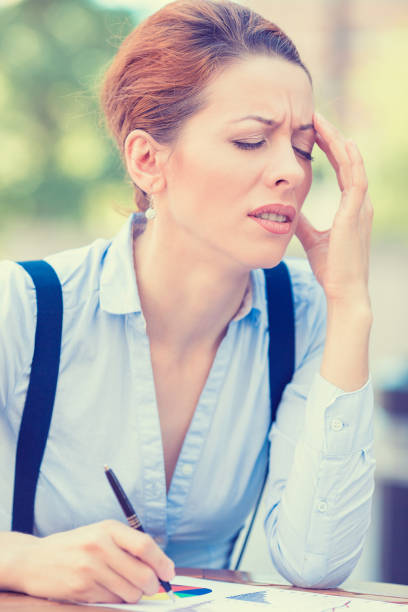 istock stressed young professional woman sitting at table outside corporate office having headache 668832302
