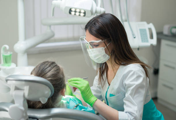 dentista donna che controlla la paziente bambina - igienista dentale foto e immagini stock