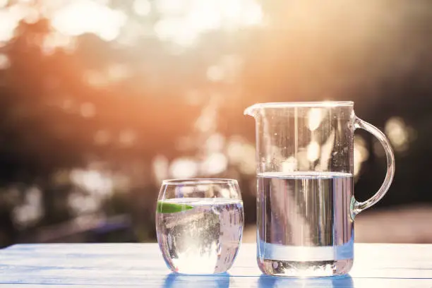 Hand Pouring Water From Pitcher Into Glass