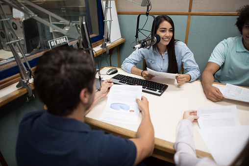 Group of Latin American students broadcasting from the university's radio station - education concepts