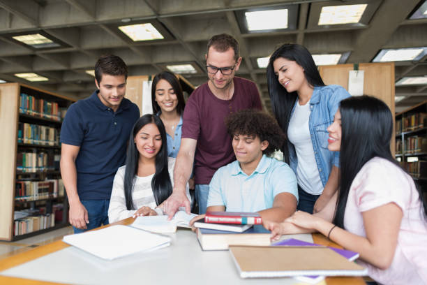 istock Group of students at a library with their teacher 668843364