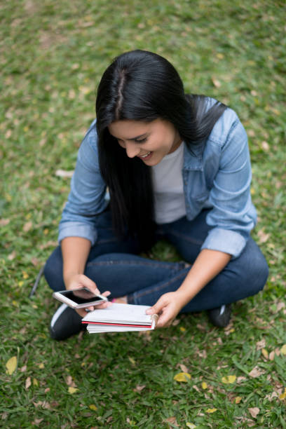 istock Female student texting on her cell phone at the university 668843412