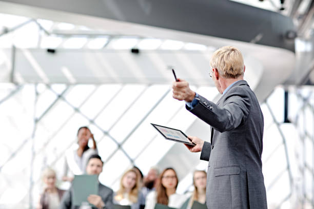 Speaker presenting at business seminar Speaker presenting at business seminar audience in lecture hall stock pictures, royalty-free photos & images