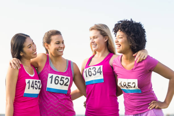 istock Four smiling runners supporting breast cancer marathon 668849818