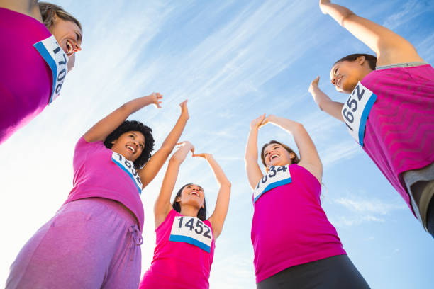 istock Five cheering runners supporting breast cancer marathon 668852778