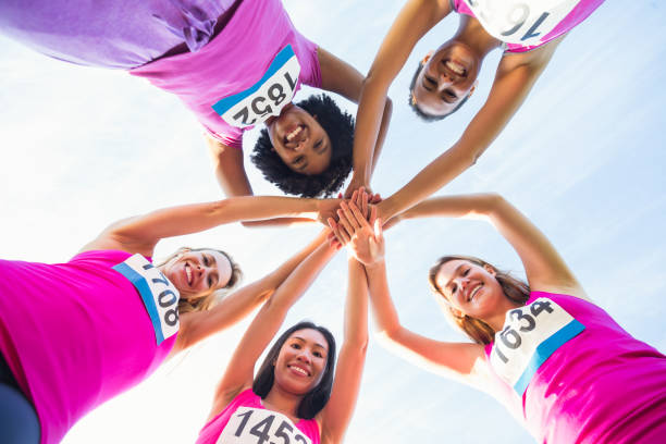 istock Five smiling runners supporting breast cancer marathon 668852788