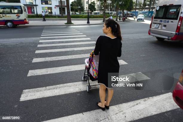 Hanoi Vietnam Oct 19 2016 Mother With A Baby Stroller Crossing The Street In Minh Khai Vehicles Running On Street Stock Photo - Download Image Now
