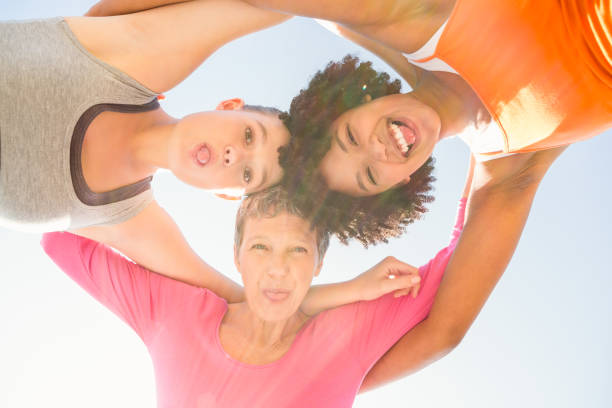 istock Sporty women with arms around posing down to camera 668876672