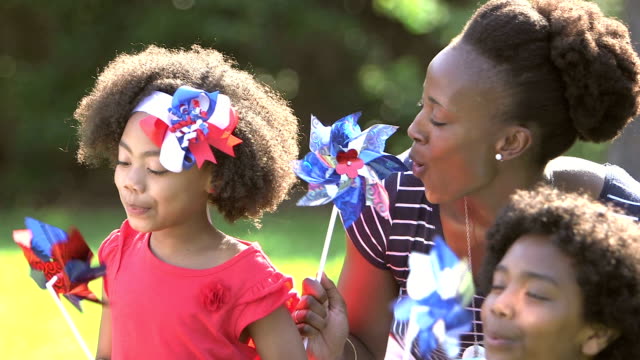 Black mother and children playing on American holiday