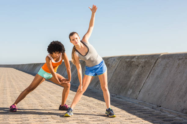 istock Two young woman stretching together 668876936
