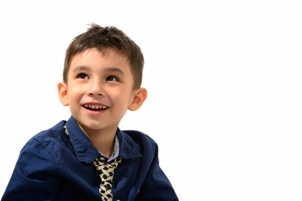Close up of cute happy boy smiling and thinking while looking up horizontal shot