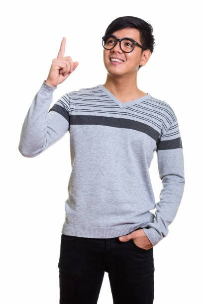 istock Studio shot of happy Asian man standing and pointing finger up while thinking 668887712