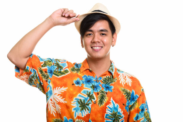 istock Young happy Asian tourist man smiling while holding hat 668888868