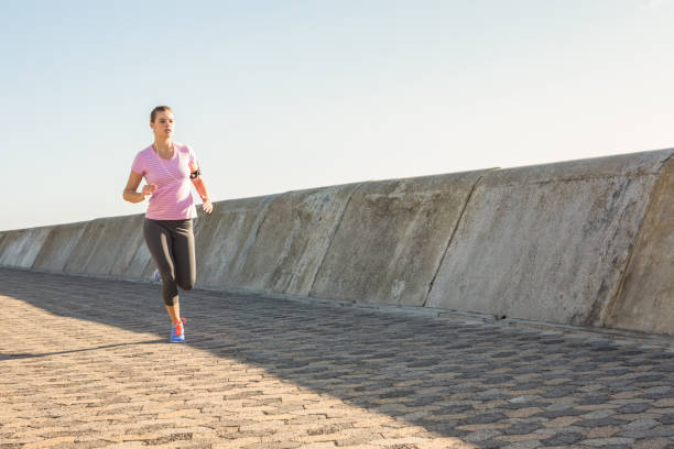 istock Sporty blonde jogging at promenade 668894400