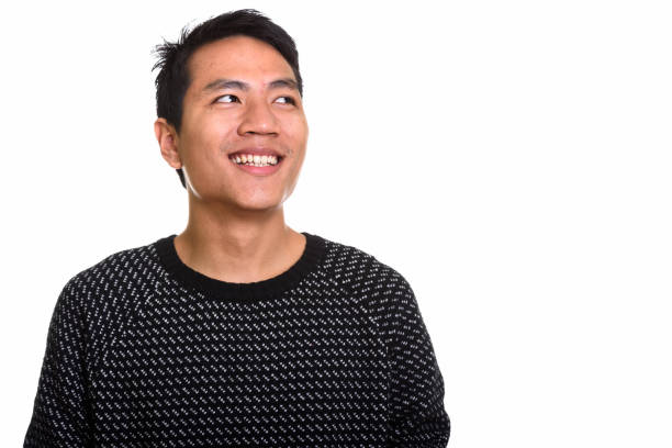 istock Studio shot of young happy Asian man smiling while thinking 668894422