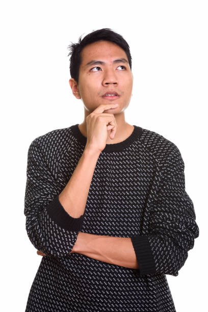 istock Studio shot of young Asian man thinking with hand on chin 668894428