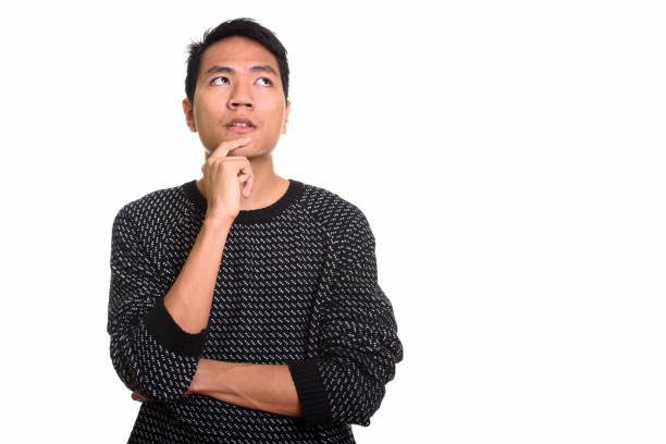 istock Young Asian man thinking while looking up with hand on chin 668894472