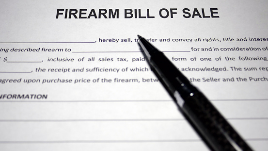 Someone filling out Firearm Bill of Sale.