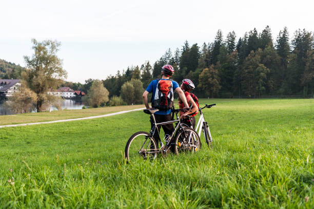 istock Young couple walk bikes by lake 668927772