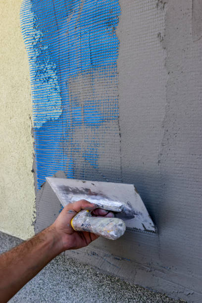 istock Spreading mortar on mesh of styrofoam insulation wall 668934346