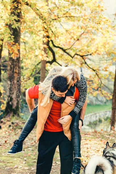 istock Young Smiling Couple Piggybacking During Autumn Day 668945090
