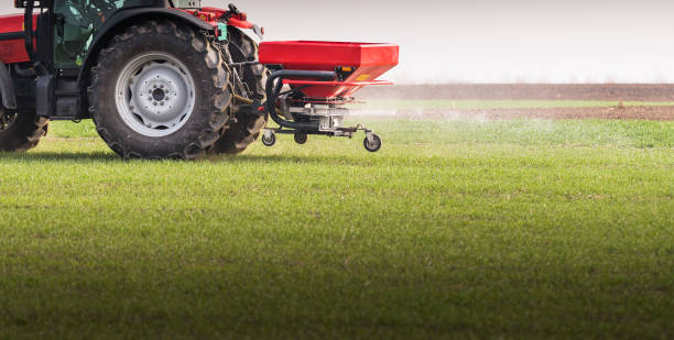 istock Tractor spreading artificial fertilizers  in field 668948352