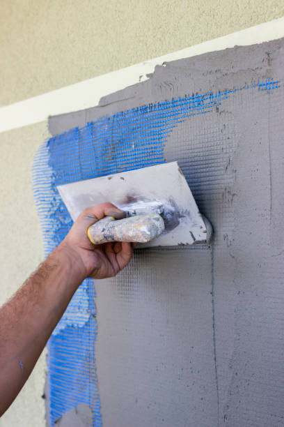 istock Spreading mortar on mesh of styrofoam insulation wall 3 668954474
