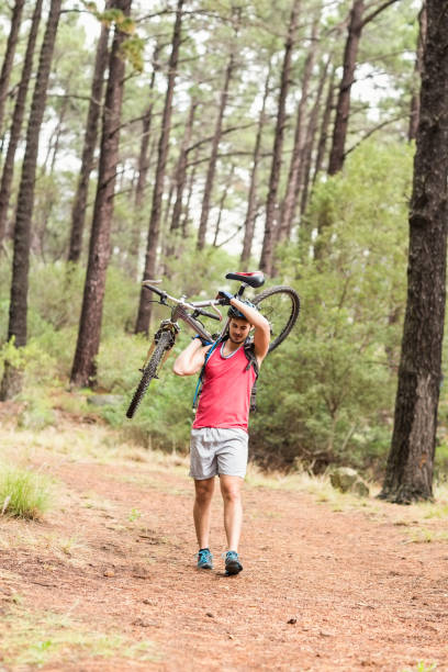 istock Happy handsome biker holding bike 668955904