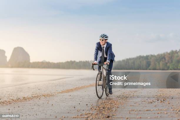 Giovane Uomo Daffari Asiatico In Bicicletta Rilassando La Spiaggia Al Tramonto - Fotografie stock e altre immagini di Abbigliamento da lavoro