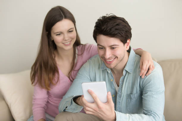 istock Young happy smiling couple using tablet, video call, online shopping 668986428
