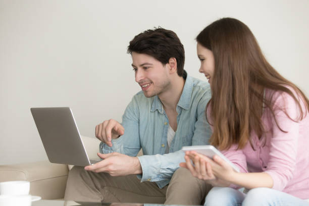 istock Young man and woman using laptop, tablet, talking, shopping online 668986454