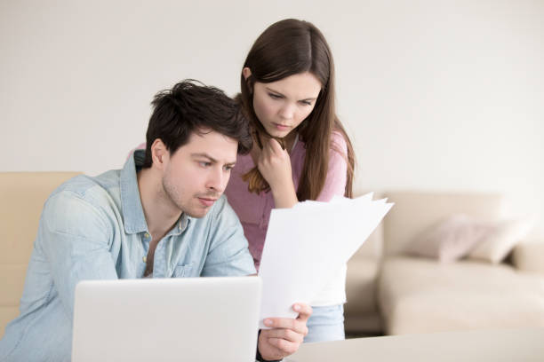 istock Couple looking at documents, calculating bills, reading letters, analyzing finances 668986710
