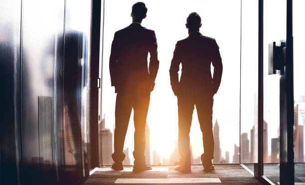 istock Businessmen looking out the office window 668987328
