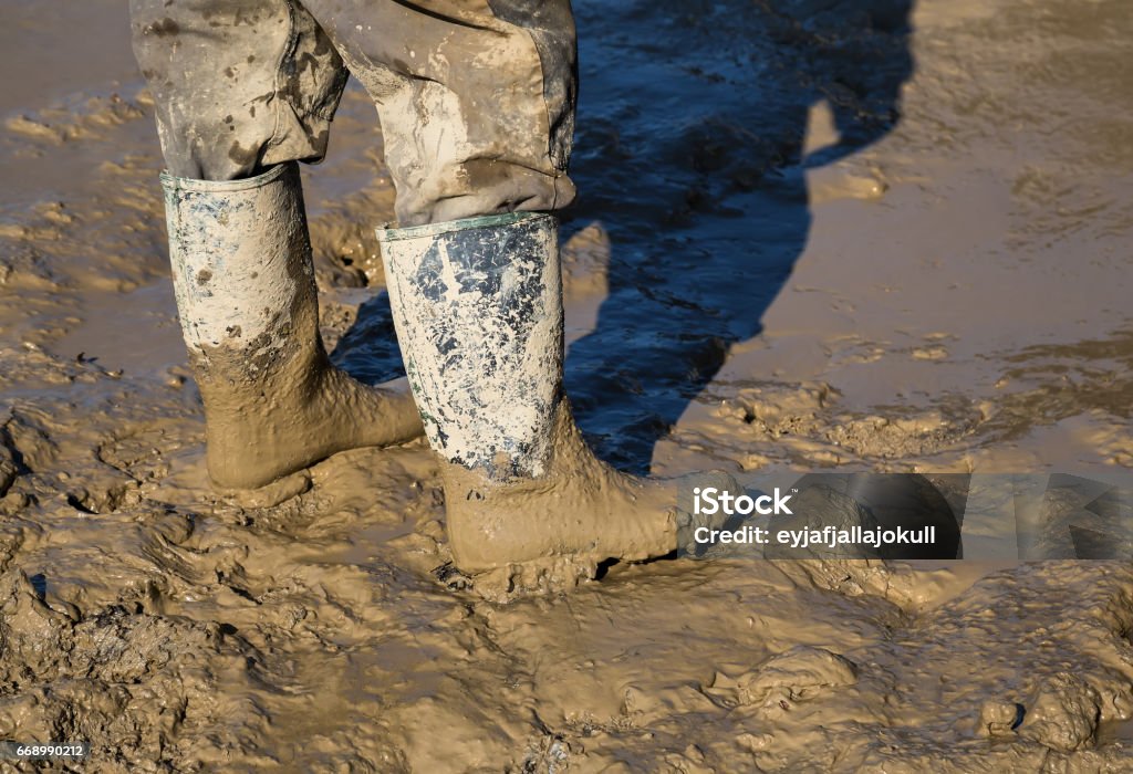Muddy work boots Muddy work boots, human leg with dirty rubber boots. Made with shallow dof. Boot Stock Photo