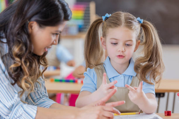 istock Adorable schoolgirl counts on fingers in class 669003284