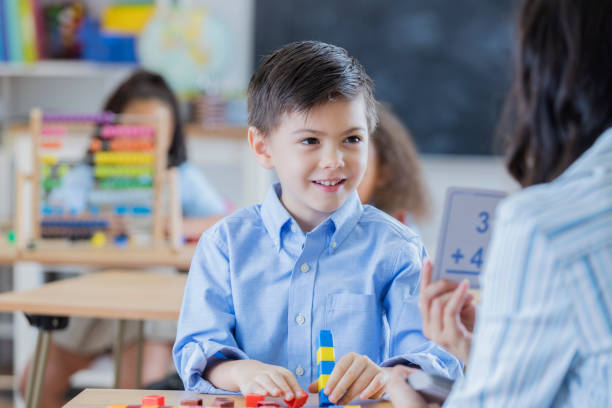 istock Teacher shows flash cards to young male student 669003296